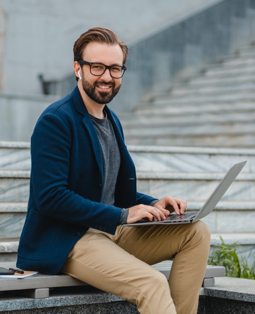 handsome busy bearded man working in park